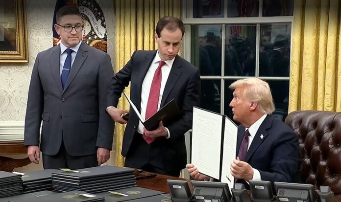 Trump in Oval Office on January 20, 2025 signing executive orders and pardons