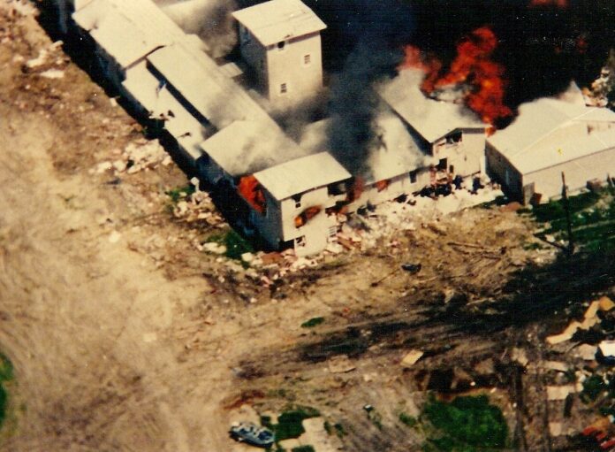 The Mount Carmel Center engulfed in flames on April 19, 1993, during the final assault by federal authorities at the end of the 51-day Waco siege. (Image credit: Federal Bureau of Investigation, via Wikimedia Commons, Public Domain).