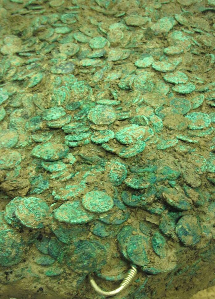 The Le Câtillon II hoard (also known as the Grouville Hoard) during conservation work in 2012. This unprecedented discovery contained approximately 70,000 Celtic coins, gold torques, and jewelry, providing valuable insights into Iron Age trade networks and Celtic responses to Roman expansion. Image from Wikimedia Commons, photo credit: Man vyi, released to the public domain.